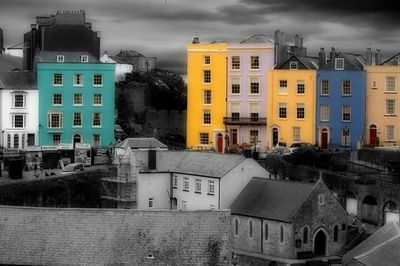 Buildings in city against cloudy sky