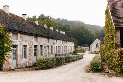 France - september 18 2016. facade of old french building is entwined with ivy. yard of an old abbey