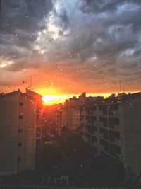 Buildings in city against sky during sunset