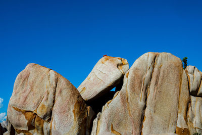 Low angle view of stack against blue sky