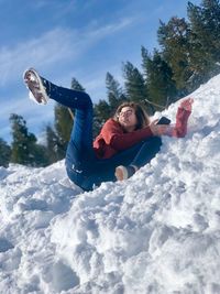 Boy in snow against sky during winter