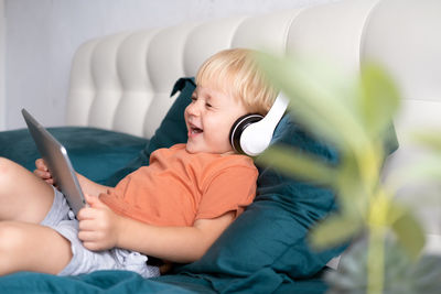 Cute boy listening cartoon in digital tablet