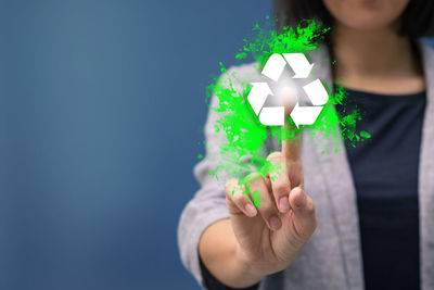 Digital composite image of woman touching recycling symbol
