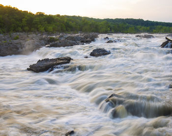 Scenic view of water flowing over rocks in sea