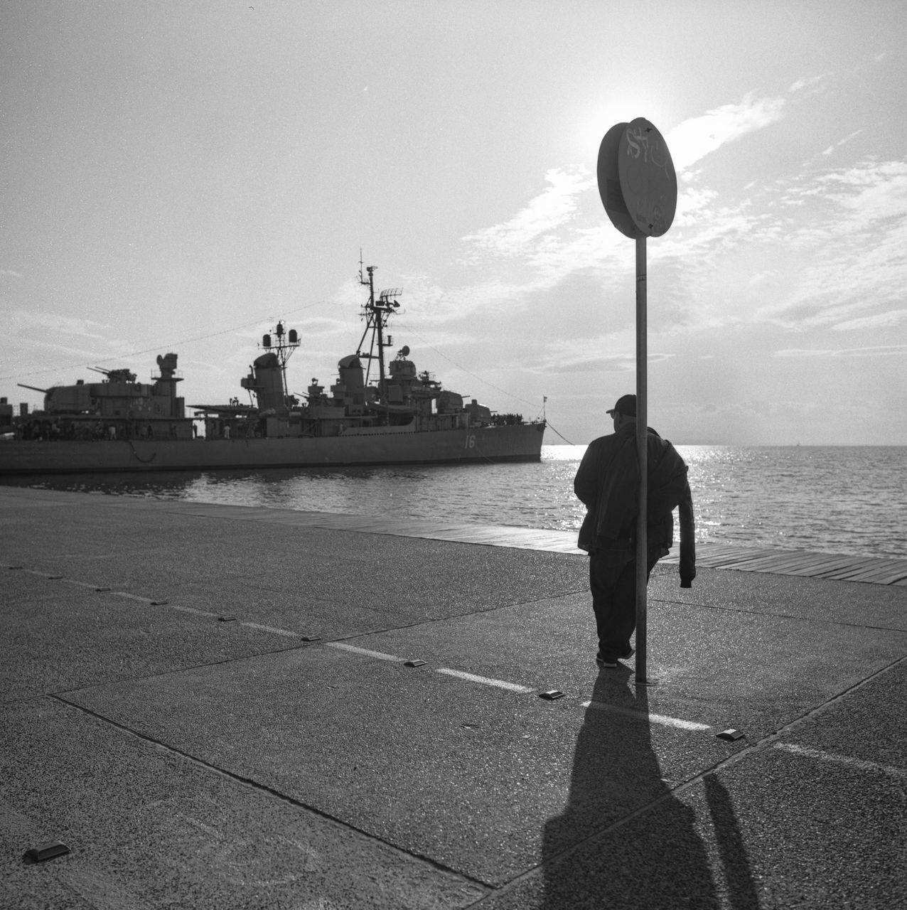 sky, black and white, monochrome, white, black, nature, water, monochrome photography, one person, sea, vehicle, full length, ship, transportation, architecture, men, adult, city, day, cloud, sunlight, standing, outdoors, lifestyles, horizon, person, leisure activity, rear view, travel destinations, travel, silhouette, built structure