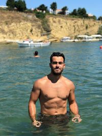 Portrait of shirtless man standing in water
