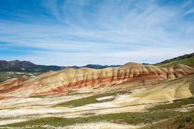 Scenic view of landscape and mountains against cloudy sky