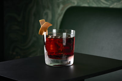 Negroni drink in front of green sofa