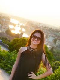 Portrait of smiling young woman against sky