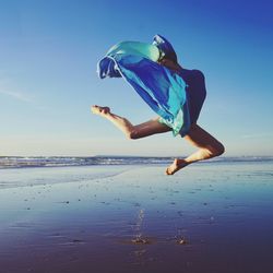 Man jumping in sea against sky