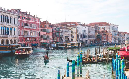 Boats in canal against buildings in city