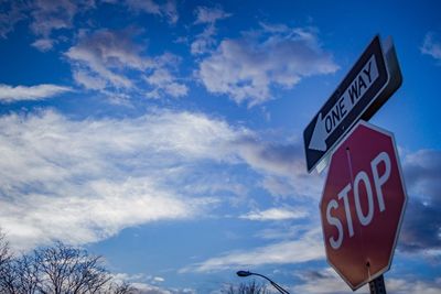 Low angle view of road sign against sky