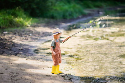 Full length of boy fishing in river