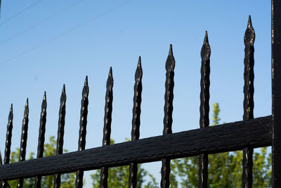 Low angle view of wooden fence against clear blue sky