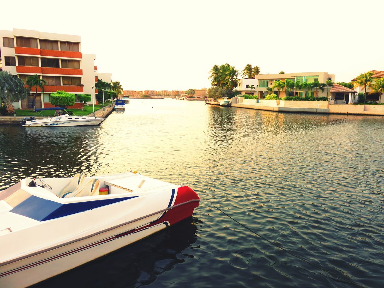 water, clear sky, nautical vessel, boat, built structure, waterfront, building exterior, moored, architecture, transportation, tree, mode of transport, rippled, river, reflection, day, lake, house, canal, nature