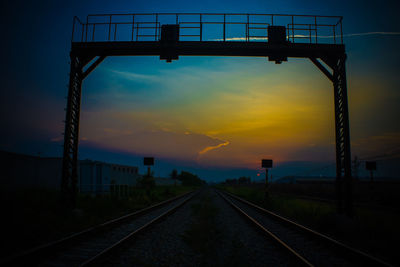 Railroad tracks against sky during sunset