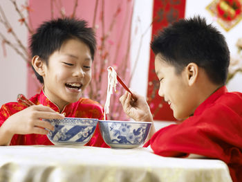 Boys having soup while sitting at table during festival