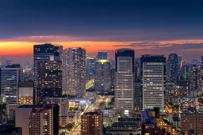 Illuminated buildings against sky during sunset