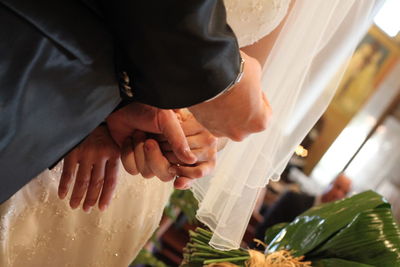 Midsection of newlywed couple standing during wedding