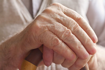 Midsection of senior person holding walking cane