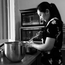 Side view of young woman standing at home