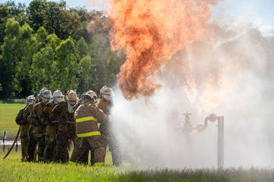 Rear view of man standing amidst smoke