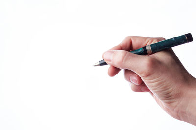 Close-up of hand holding pen against white background
