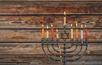 Close-up of illuminated lighting equipment hanging on wooden wall