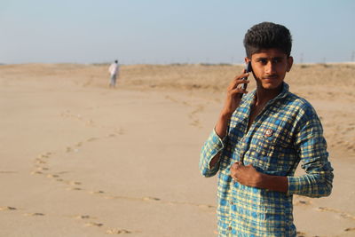 Portrait of young man standing on beach
