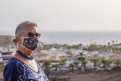 Close-up of senior woman wearing mask standing outdoors