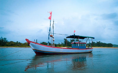 Boat moored in sea against sky