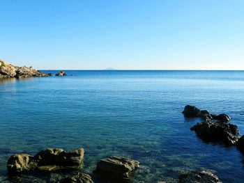 Scenic view of sea against clear blue sky