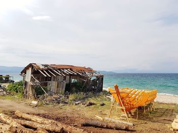 Abandoned built structure on beach against sky