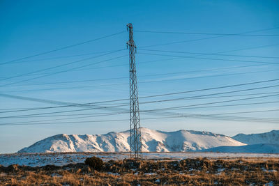 Electric pole against mountains