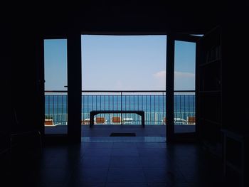 Entrance of building against sky seen through window