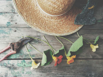 High angle view of flowers and hat on wooden table