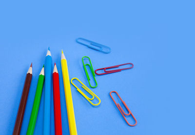 High angle view of colored pencils against blue background
