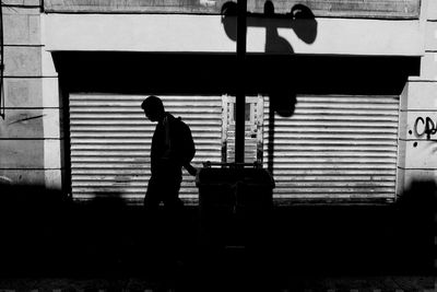 Side view of a silhouette man against the wall