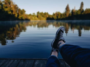 Low section of person relaxing on lake