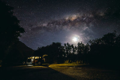 Trees on field against sky at night