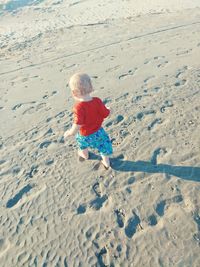 High angle view of baby boy walking on sandy beach