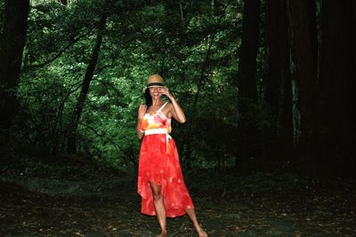 Full length of woman standing in forest