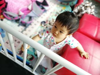 High angle view of girl sitting in bedroom at home