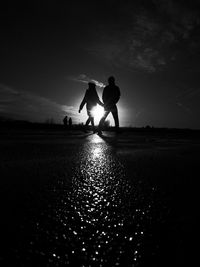 Full length of silhouette people walking on field against sky