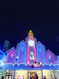 Low angle view of illuminated ferris wheel at night