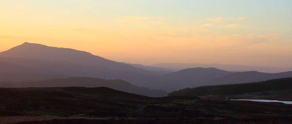 Scenic view of silhouette mountains against sky during sunset