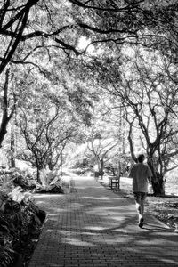 Rear view of woman walking on footpath