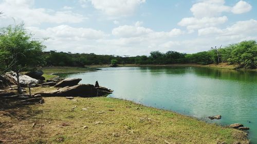 Scenic view of river against cloudy sky