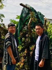 Portrait of brothers standing by plants