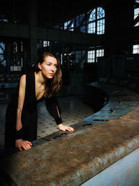 Thoughtful young woman standing in building